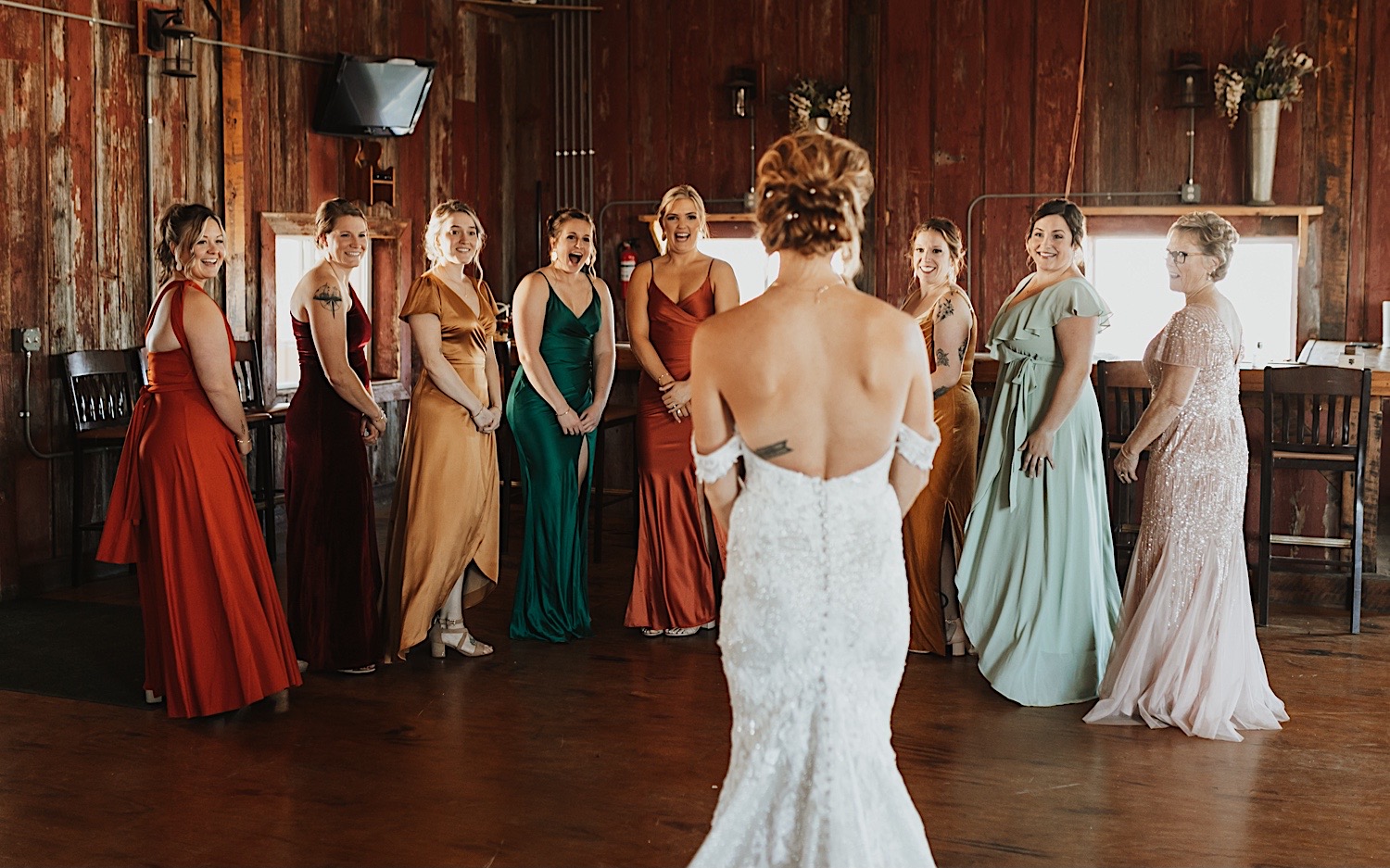 Bridesmaids smile and are excited after when they see the bride in her dress during their first look