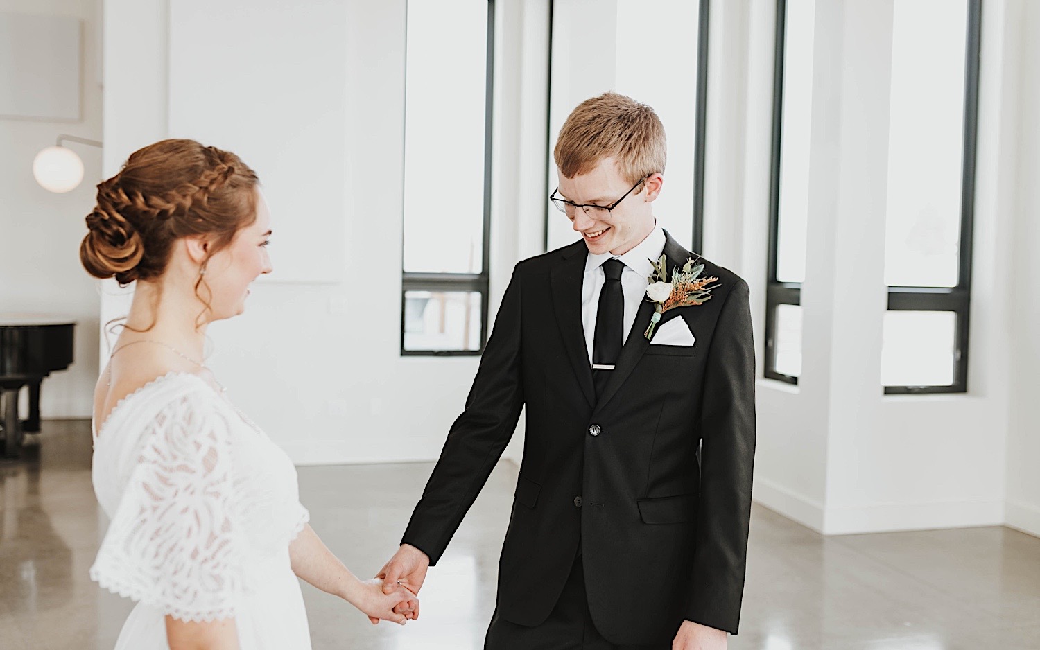 A bride and groom smile as they look at one another for the first time on their wedding day