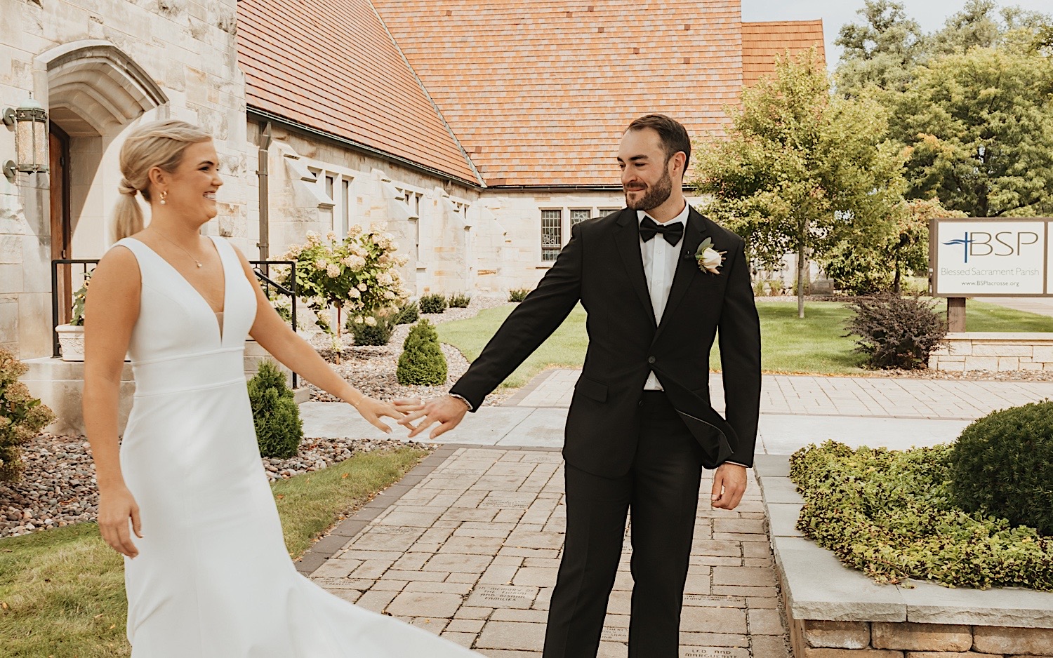 A bride and groom see one another for the first time on their wedding day and smile