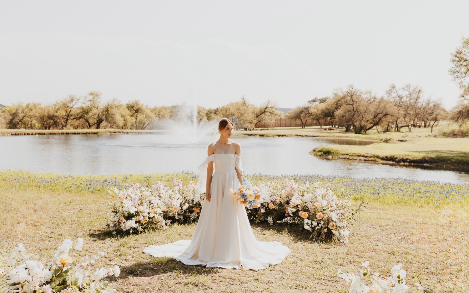 Bride stands surrounded by flowers on her wedding day in the countryside of Italy