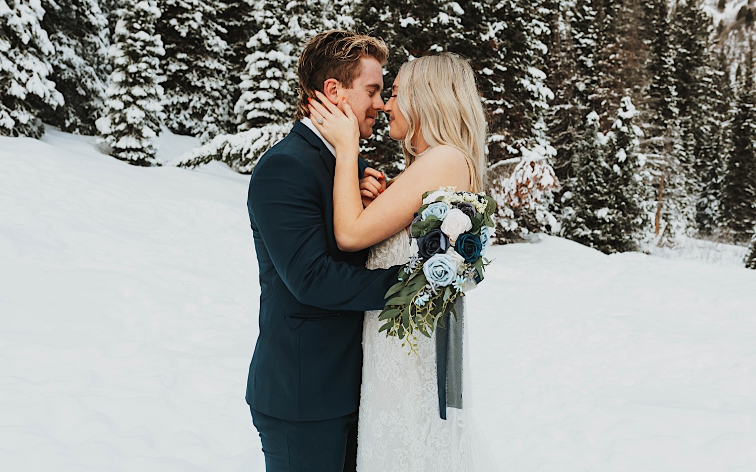 A bride and groom are about to kiss in a snow covered park near Salt Lake City after their elopement