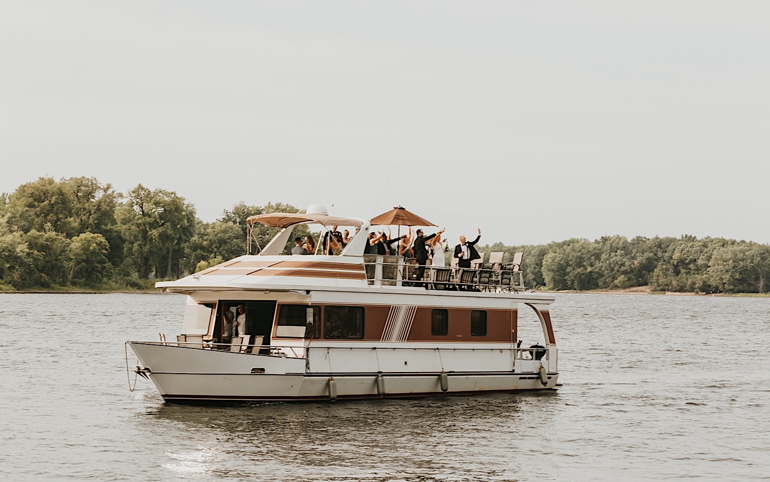 A bride, groom, and their wedding parties all ride aboard a boat before their wedding reception