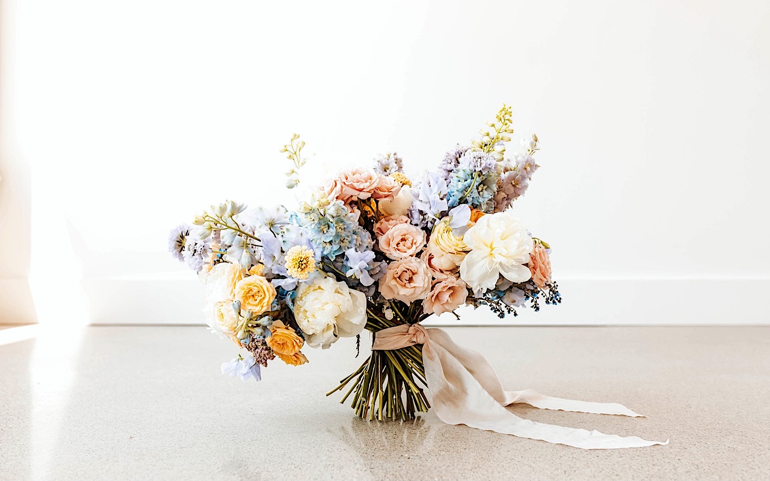 A large floral bouquet rests on the ground A large floral bouquet rests on the ground