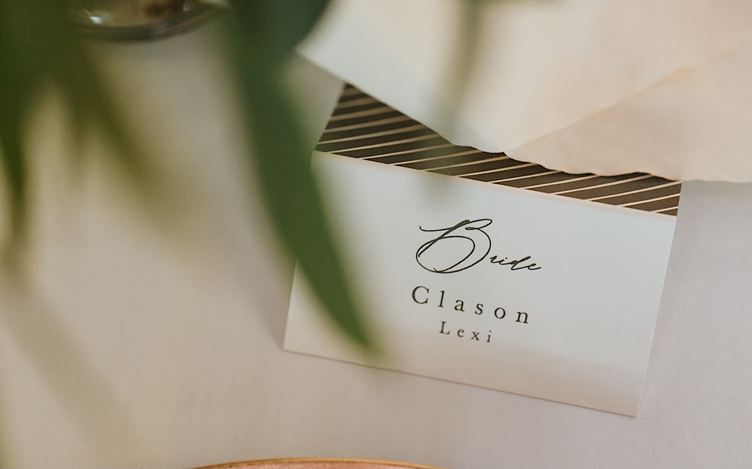 Close up photo of a table tag reading "Bride, Clason Lexi"