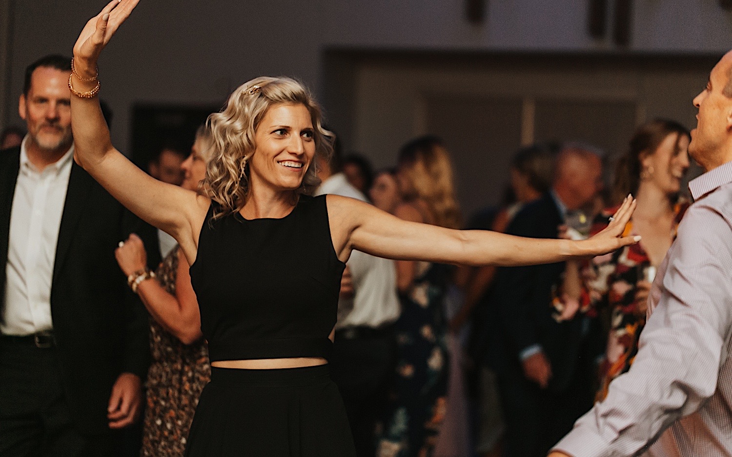 A woman dances surrounded by people during a wedding reception at the La Crosse Center