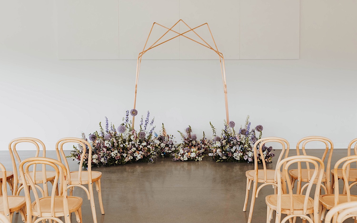 A wedding arch surrounded by flowers stands in the center of the wedding ceremony space at The Aisling A wedding arch surrounded by flowers stands in the center of the wedding ceremony space at The Aisling