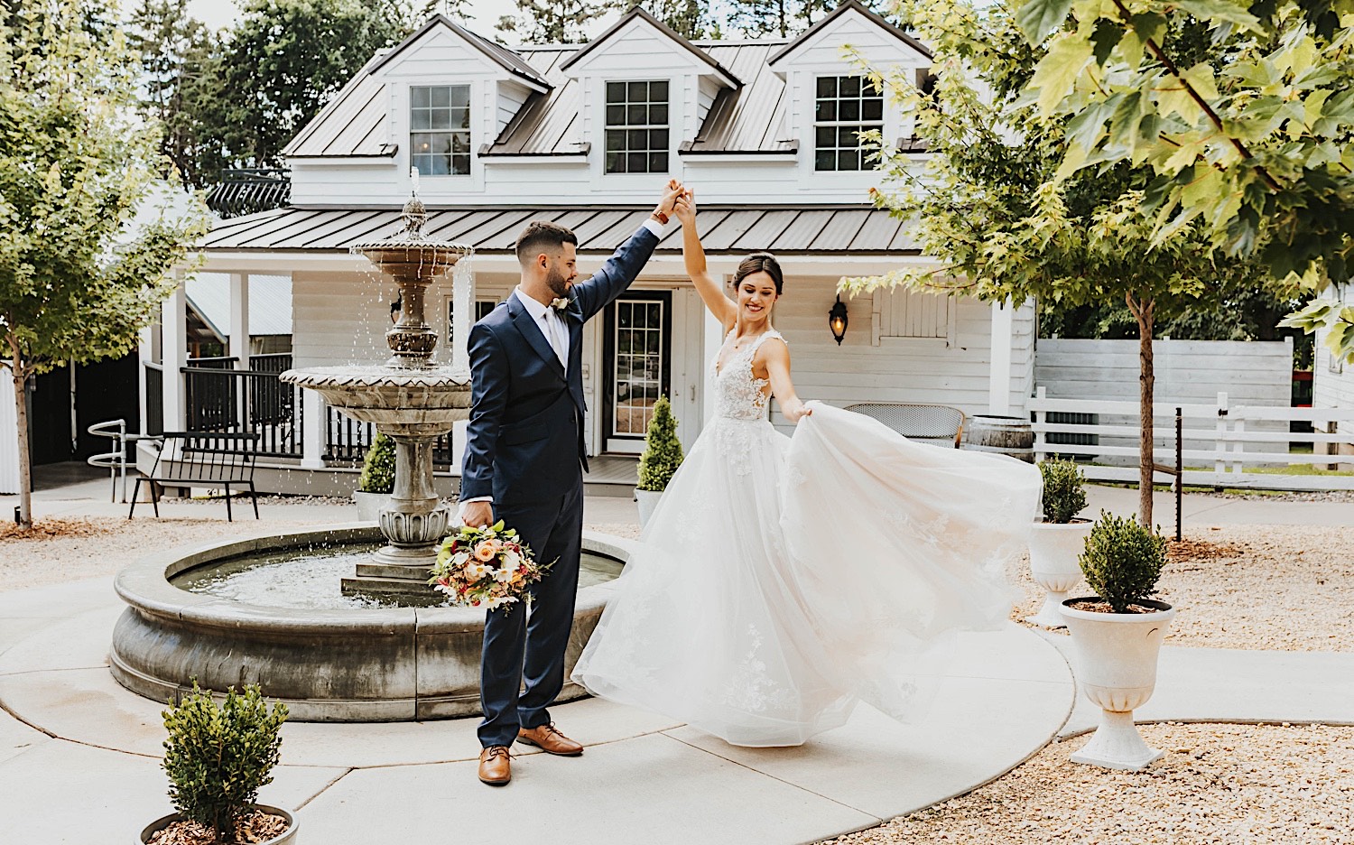 A bride and groom dance next to a fountain in a courtyard at their wedding venue Legacy Hill Farm