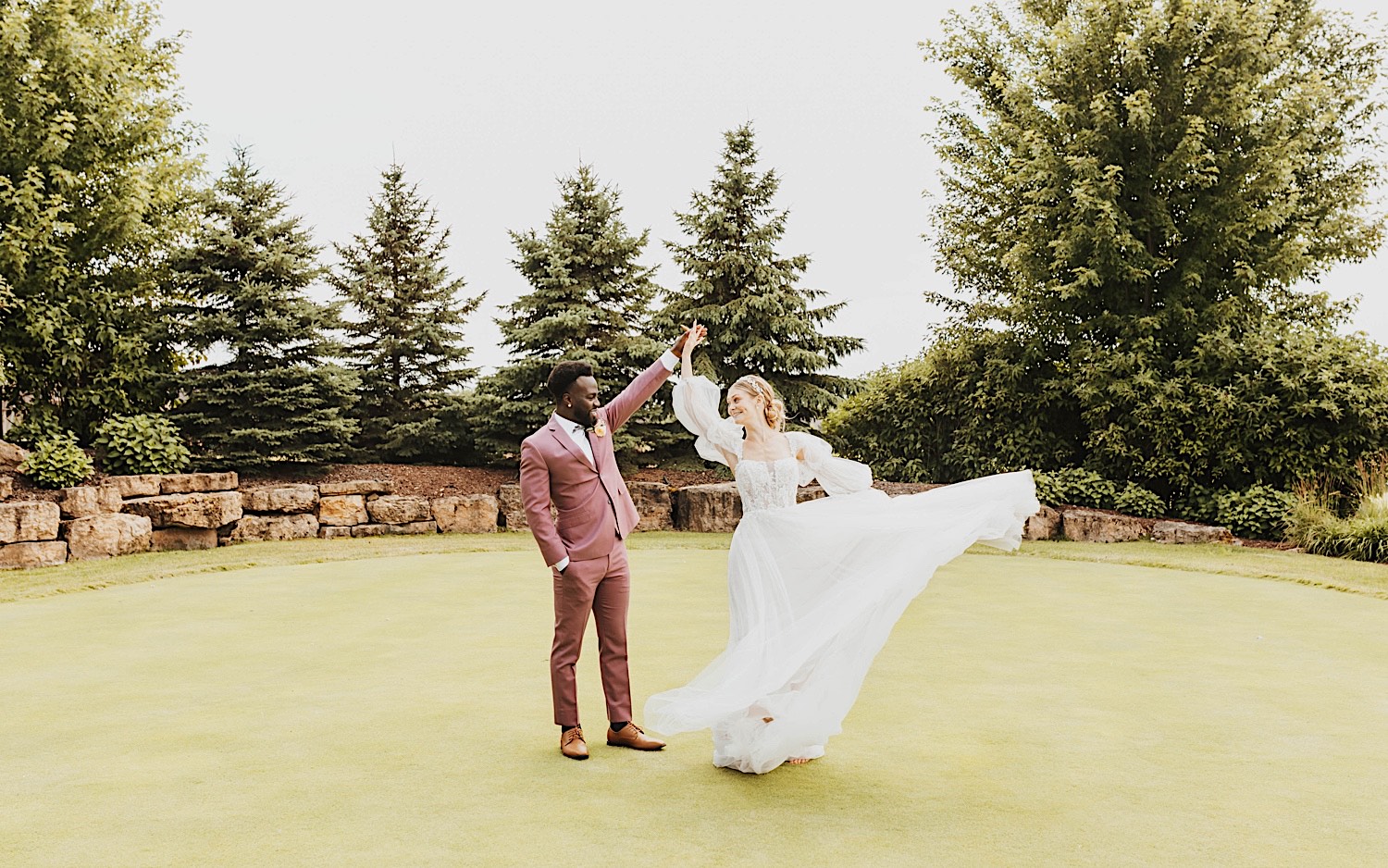 A bride and groom dance together outside of their wedding venue The Aisling on one of the golf course's putting greens