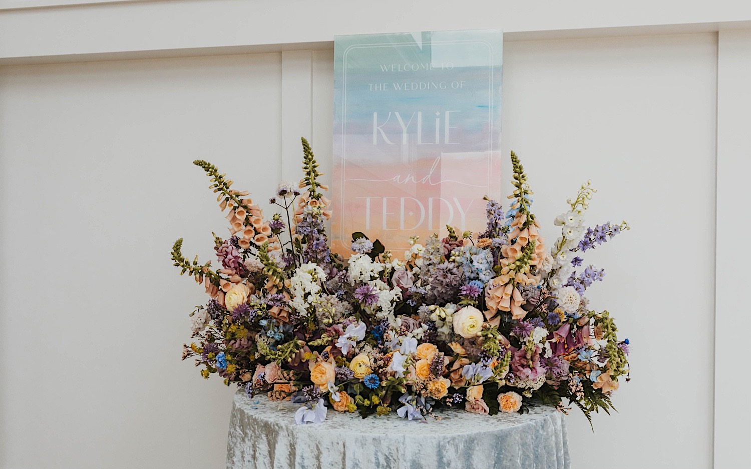 A custom sign for a wedding at The Aisling sits on a table surrounded by flowers