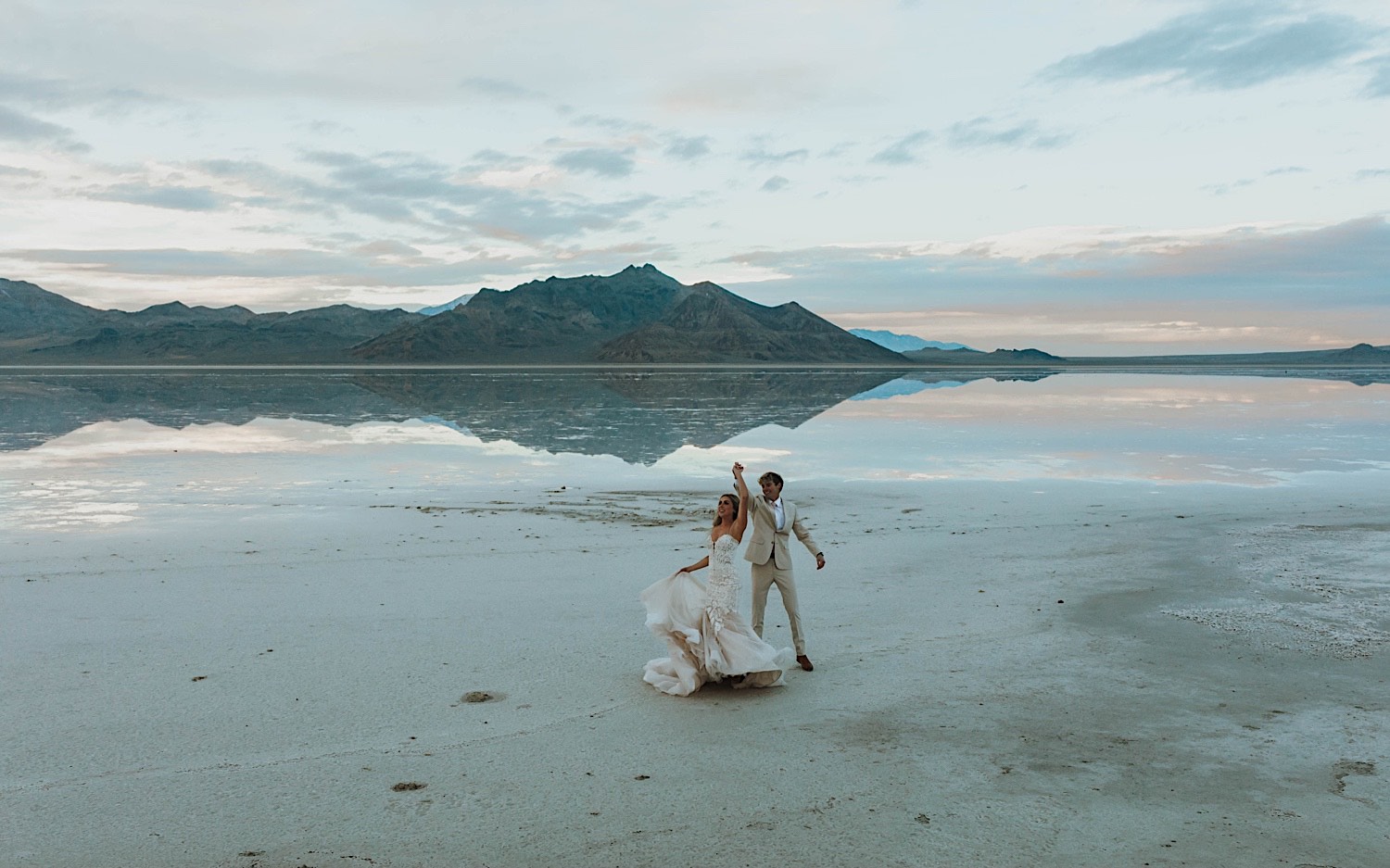 In the Utah Salt Flats, a bride and groom dance together during their elopement