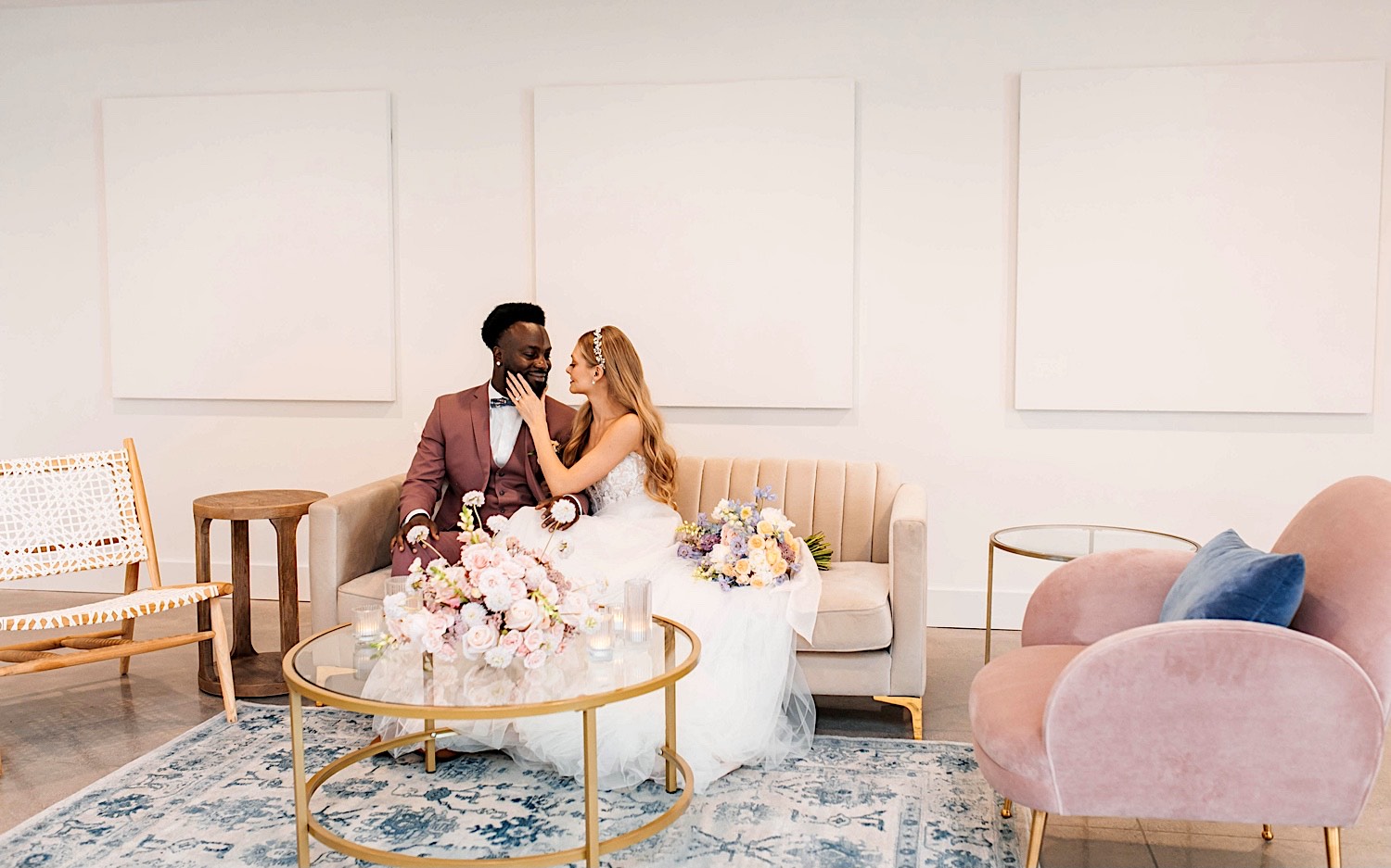 A bride and groom sit next to one another on a couch as the bride touches the groom's face during their wedding day at The Aisling A bride and groom sit next to one another on a couch as the bride touches the groom's face during their wedding day at The Aisling