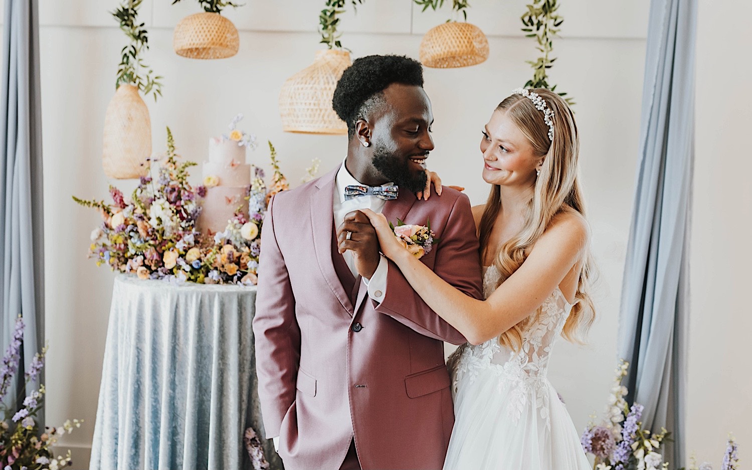 A bride and groom smile at one another while standing in front of their wedding cake during their wedding reception at The Aisling A bride and groom smile at one another while standing in front of their wedding cake during their wedding reception at The Aisling