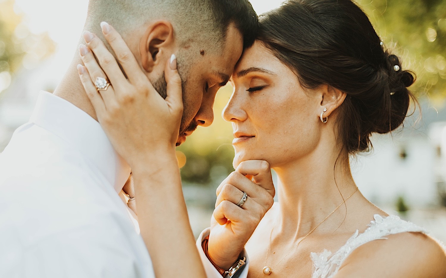 A bride and groom embrace one another while standing outside as the sun sets behind them while at their wedding venue Legacy Hill Farm