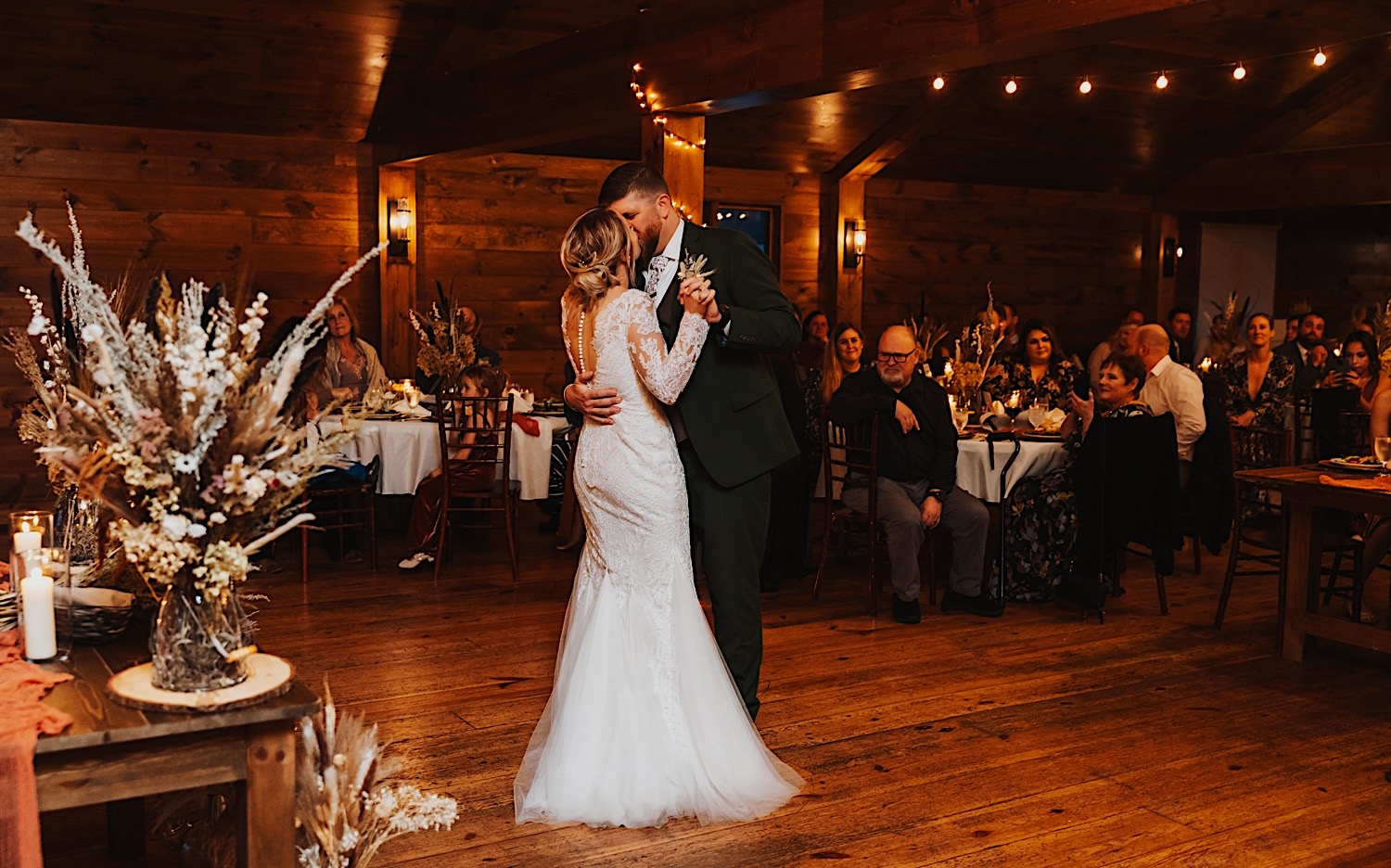 A bride and groom kiss one another while dancing during their indoor wedding reception at Lake Bomoseen Lodge in Vermont