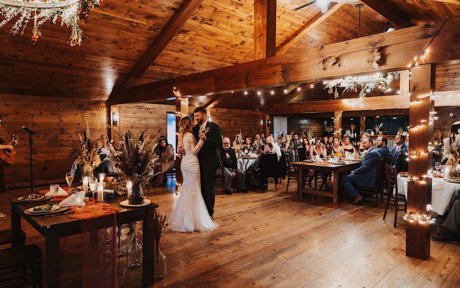 Guests watch while a bride and groom share a first dance together during their indoor wedding reception at Lake Bomoseen Lodge in Vermont