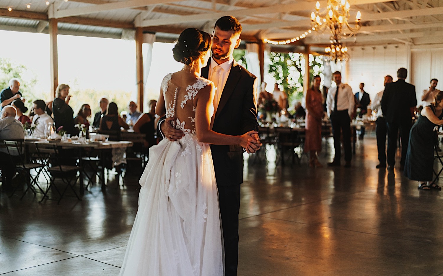 A bride and groom dance with one another during their wedding reception at Legacy Hill Farm as the sun sets