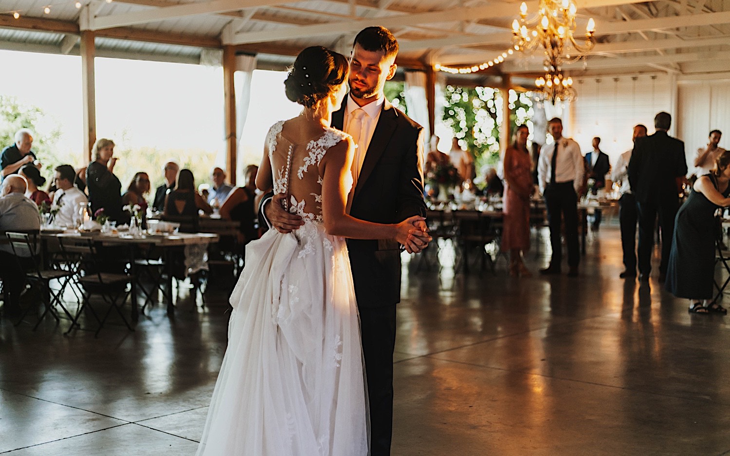 A bride and groom dance with one another during their wedding reception at Legacy Hill Farm as the sun sets A bride and groom dance with one another during their wedding reception at Legacy Hill Farm as the sun sets