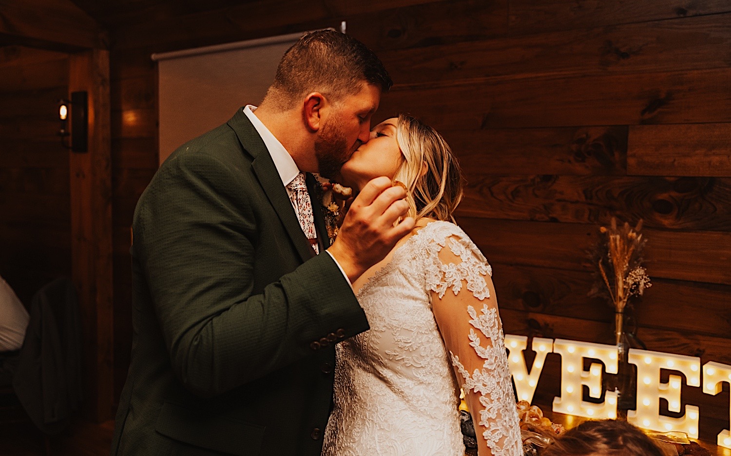 A bride and groom kiss one another during their indoor wedding reception at Lake Bomoseen Lodge in Vermont