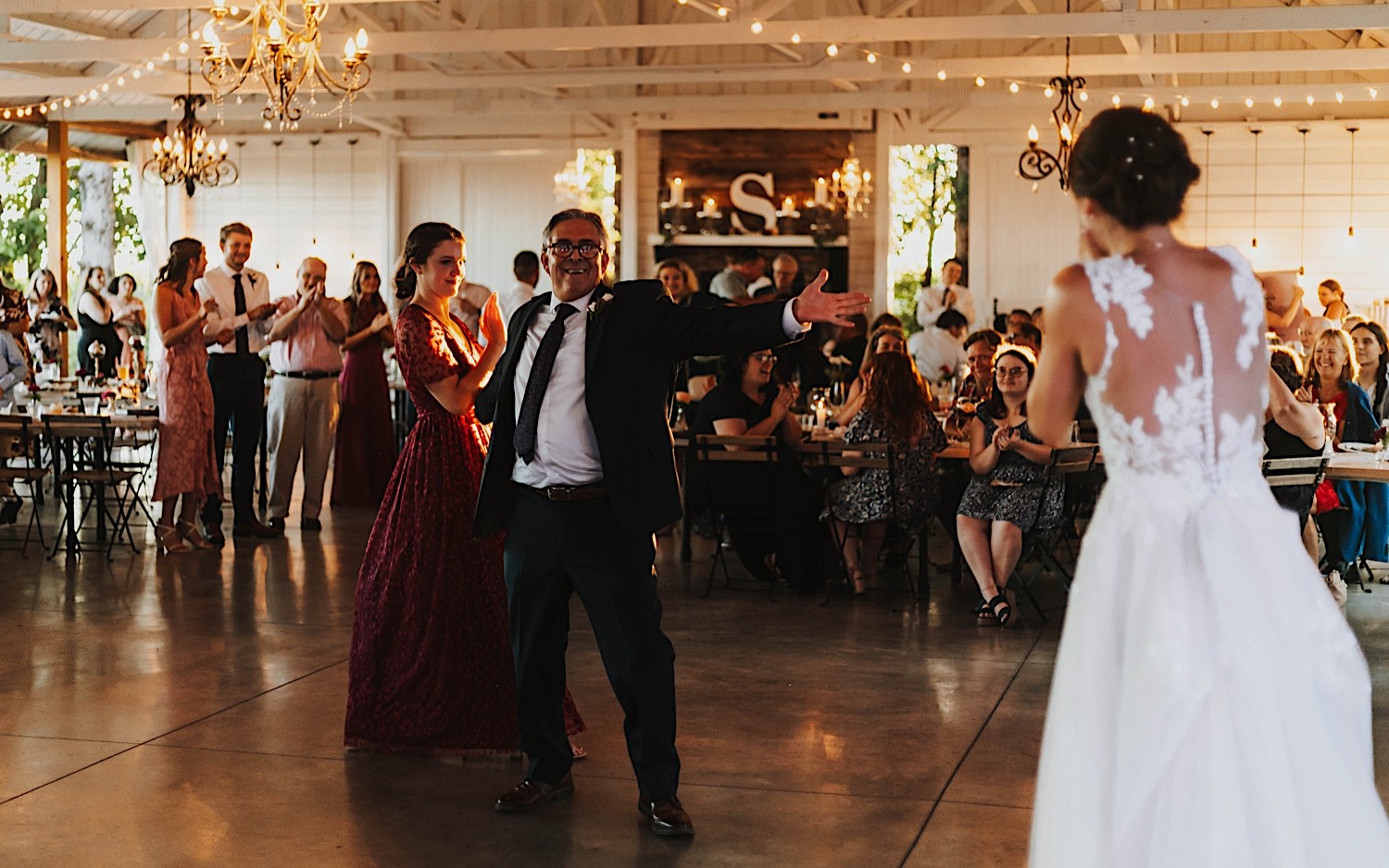 The father of the bride gestures towards her as the two dance during a wedding reception at Legacy Hill Farm