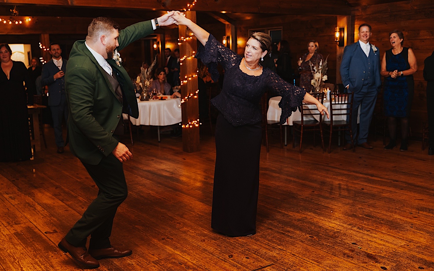 A groom and his mother share their first dance together as guests watch during an indoor wedding reception at Lake Bomoseen Lodge in Vermont